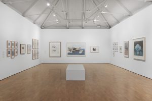 Installation photograph of Kiki Smith: I am a Wanderer featuring prints by the artist hung in a large white room with a wooden floor