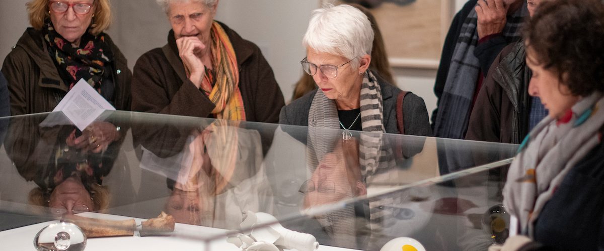 A group of people on a tour of the exhibition Kiki Smith: I am a Wanderer looking at Kiki Smith's small sculptures